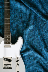 Fototapeta premium Guitar electric. Rock music background. Top view on blue textile cloth