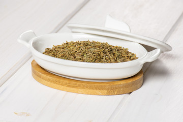 Lot of whole dry roman caraway seeds in a ceramic stewpan on white wood