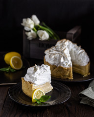 Lemon cake with white meringue on a wooden table