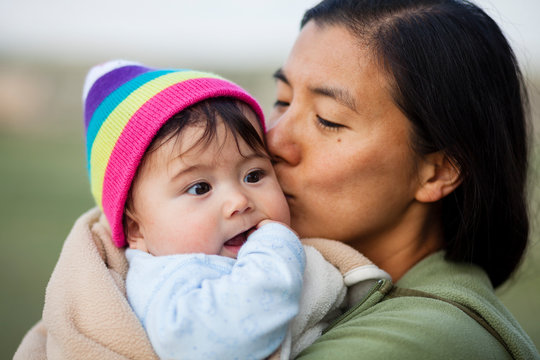 Portrait of woman kissing baby girl