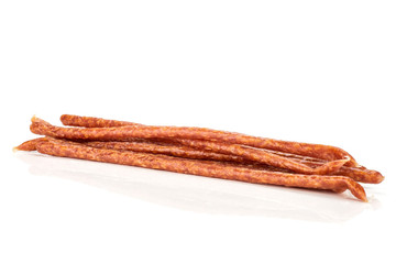 Lot of whole spicy salami stick tyrolini isolated on white background