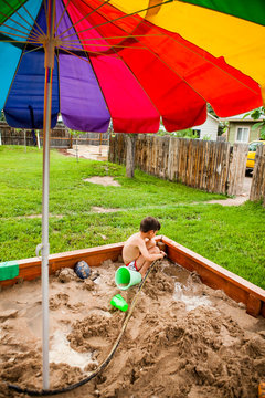 Japanese American boy playing in sandbox