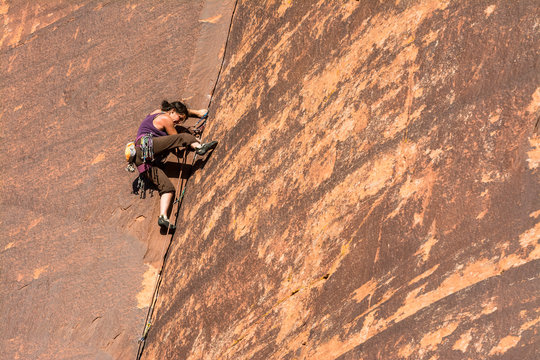 A woman rock climbing in Indian Creek, Monticello, Utah.