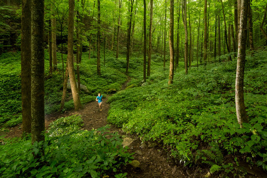 A woman trail running in Virgin Falls State Natural Area, Sparta, Tennessee.