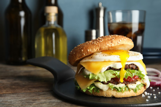 Tasty burger with fried egg on tray against blurred background, space for text