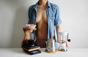 Beautiful girl in stretched shirt makes coffee. Origami dripper. Brewstation. Scale, gooseneck,...