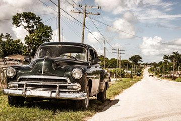 Amerikanischer Oldtimer parkt im Landesinneren am Strassenrand in der Provinz Santa Clara in Cuba - Serie Kuba Reportage