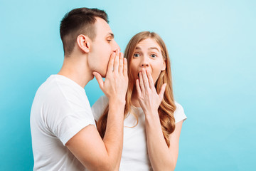 A man whispers in his ear to a woman, telling her something secret, good news