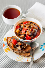 Vegetable stew with eggplant, red pepper and tomatoes on toasted rye bread