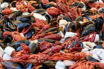 Mixed seafood cooked in a large traditional black fry pan at a street food festival, ready to eat seafood, side view, calamari, crabs, mussels with sauce