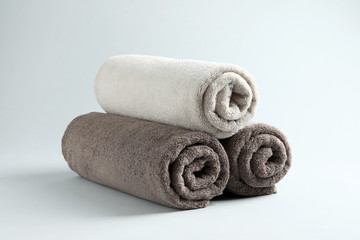 Fototapeta na wymiar Fresh fluffy rolled towels on grey background