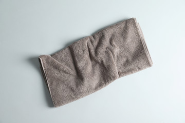 Fresh fluffy towel on grey background, top view