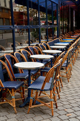 Street Cafe with empty tables and chairs on street in Paris, France