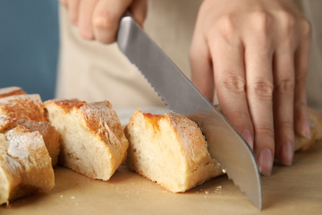 Woman cutting bread on parchment paper, closeup