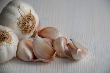 Top view of white garlics on white wooden background