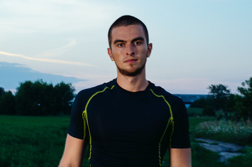 Naklejka premium portrait of a boy in a sports Jersey. beautiful brunette at sunset