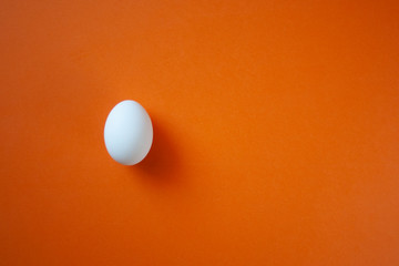 One single white egg on the bright red background with space for text. White easter egg minimal composition. Easter clean blank.