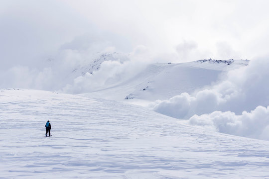 A snowboarder touring up Mt. Asahi towards the fume holes