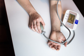 Woman measuring her blood pressure. Pulse measuring device showing low blood pressure reading. Hypotension. Heart health, healthcare and medical concept, self-care