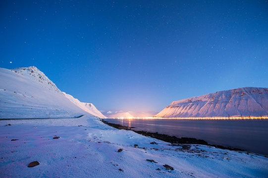 Small village lite up at twilight in Westfjords of Iceland 