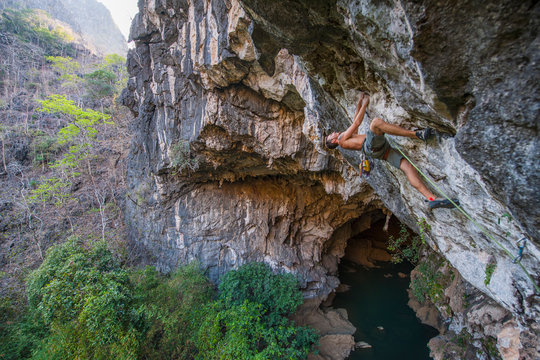 Man climbing above cave in Thakhek - Laos