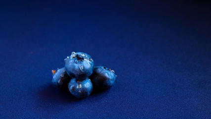 juicy summer berry is blueberries with drops of honey on a blue background