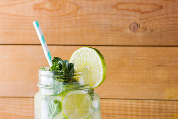 Mojito and mint on wooden background. Refreshing cocktail with lime and fresh mint on wooden...
