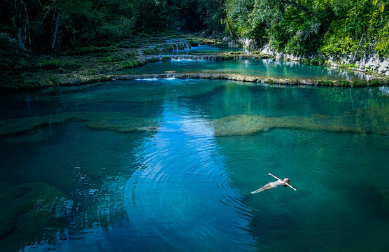Woman in bikini floating on water in river at Semuc Champey, Guatemala