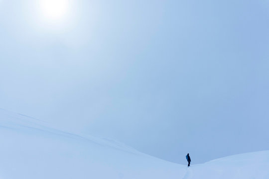 A snowboarder riding into the abyss