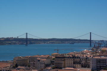 Obraz premium twenty fifth april bridge and lisbon skyline