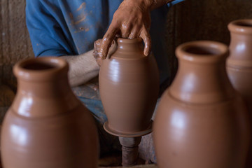 ceramic workshop - the man  makes a pot of clay on a potter's wheel