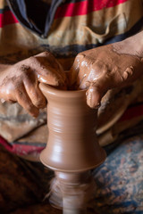 ceramic workshop - the man  makes a pot of clay on a potter's wheel