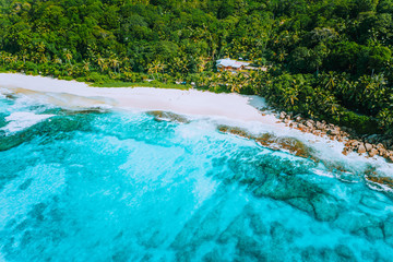 Aerial drone photo of great tropical dream beach Anse Bazarca, Mahe island, Seychelles. White powdery sand, azure water, lush vegetation, granite rocks