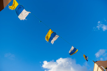 Four flags of the canary islands fluttering in the wind against blue sky