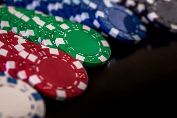 Selective focus on colorful casino chips on dark background