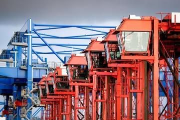 Rote Containerkräne stehen in einer Reihe