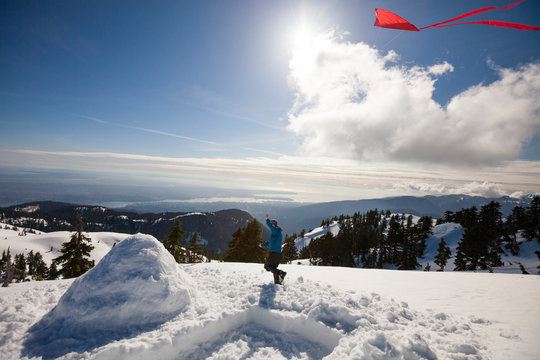 Flying A Kite On A Snowy Mountain.