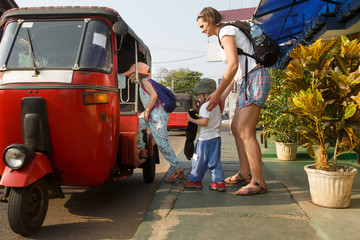 Family on vacation, mother and kids getting in a tuk-tuk, having fun. - 257520542