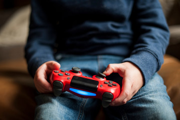 Boy moving buttons on video game controller while playing video game