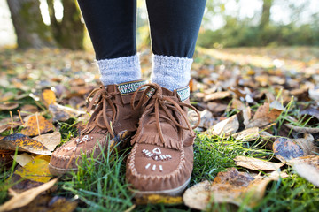 Moccasin shoes on legs of woman in park