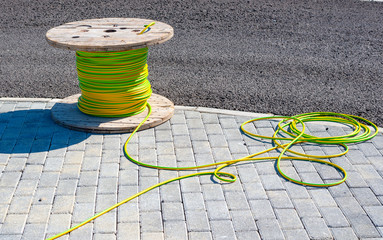 wire electric cable with wooden coil of electric cable waiting to be slipped into the conduit