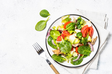 Green salad with chicken and vegetables on white.