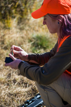 Female hunter reloading rifle magazine, Colorado, USA
