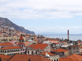 a panoramic rooftop view of the old town in funchal madeira with the sea and mountains in the...
