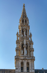 Fototapeta na wymiar The tower of The Brussels Town Hall in Brabantine Gothic style with lavishly pinnacled octagonal openwork. Atop the spire stands gilt metal statue of the archangel Michael, patron saint of Brussels.