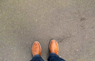 Two brown shoes on the pavement