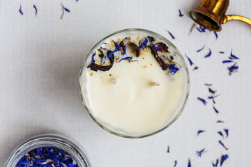 Handmade soy wax candle in glass on white background and ingredient for candle making. Top view. Healthy lifestyle concept