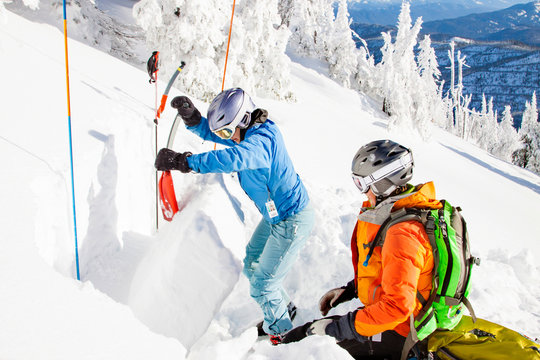 Two Female Skiers Dig An Extended Column Test Snow Pit To Judge The Avalanche Risk