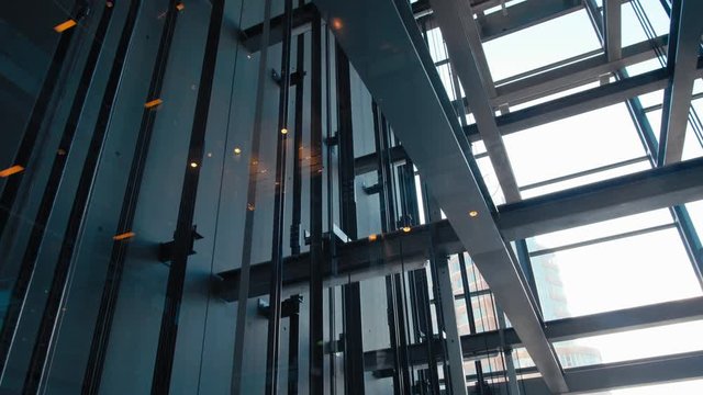 Elevators in Modern Office Business Building are Moving Up in Transparent Glass Lift Shaft in Skyscraper