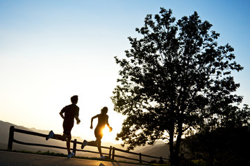 Couple road running at sunset